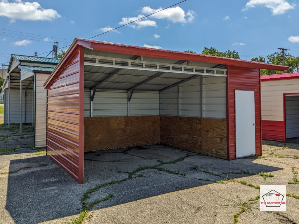 Corner of metal free standing lean to with an open section and a 4’ enclosed section that has a man door.