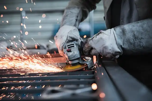 Metal building and structure manufacturer employee cutting galvanized steel tubing. In this specific photo he's cutting 12 gauge vs 14 gauge steel, as 12 gauge galvanized steel is better than 14 gauge galvanized steel.