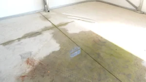 Metal garage building that has freestanding water in it that has leaked in from outside during heavy rain due to an insufficient concrete installation and lack of base rail sealant. Had the customer had expandable weather sealing foam underneath the square tubing, this would have been prevented.