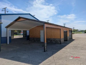 Cheap and affordable high-quality metal garage with vertical roof and vertical siding with attached carport and storage section manufactured by The Carport Company