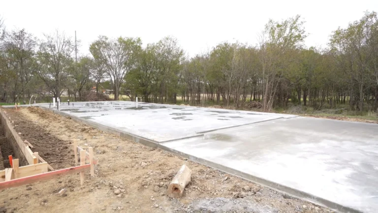 Concrete slab that was poured for the installation of a prefabricated metal garage building with notches for the roll up doors and walk in doors. The nothces help prevent leaking and seepage of water and other moisture, helping to seal the metal building.